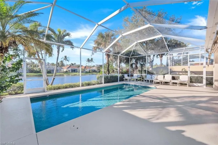 View of pool with a patio, a water view, and a lanai
