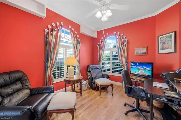 Office space with ceiling fan, ornamental molding, and light wood-type flooring