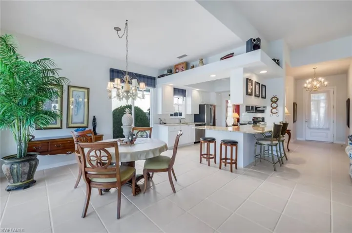 Dining space featuring light tile patterned floors, a notable chandelier, and sink