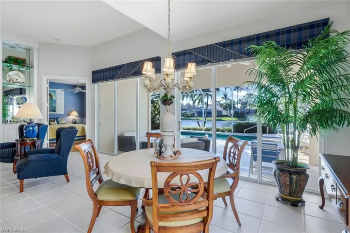 Tiled dining space featuring a notable chandelier
