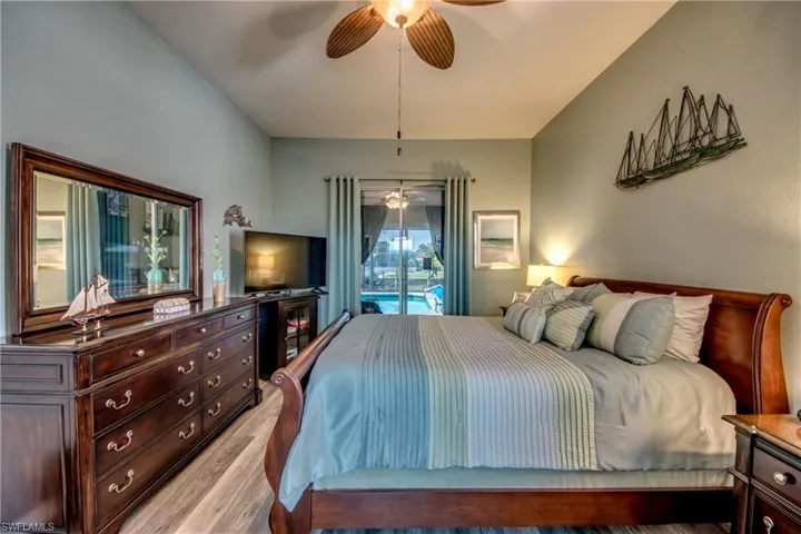 Bedroom with access to exterior, ceiling fan, and light hardwood / wood-style floors