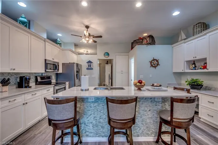Kitchen featuring a kitchen bar, sink, hardwood / wood-style floors, and stainless steel appliances