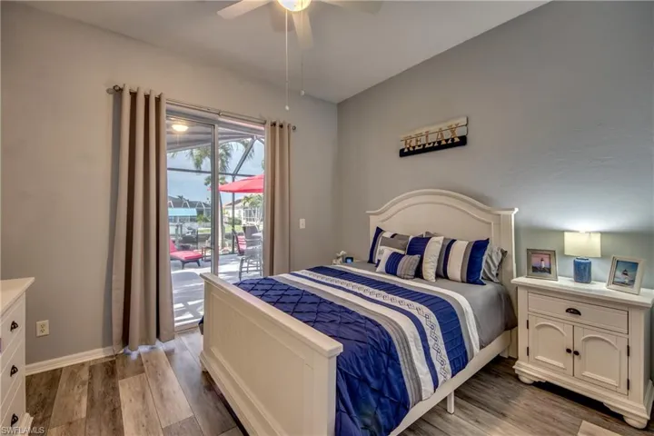 Bedroom with access to outside, ceiling fan, and hardwood / wood-style floors