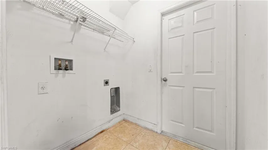 Laundry room with tile patterned flooring, washer hookup, and hookup for an electric dryer