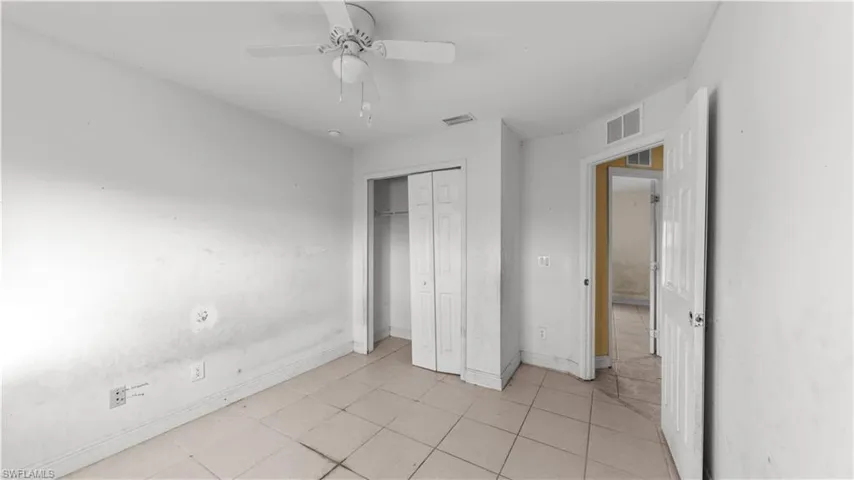 Unfurnished bedroom featuring ceiling fan, a closet, and light tile patterned floors