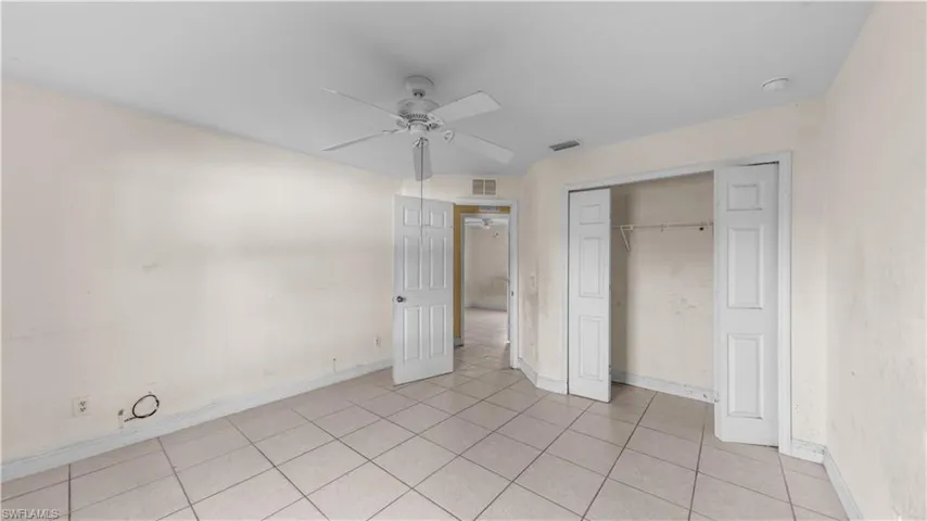 Unfurnished bedroom featuring ceiling fan, a closet, and light tile patterned flooring
