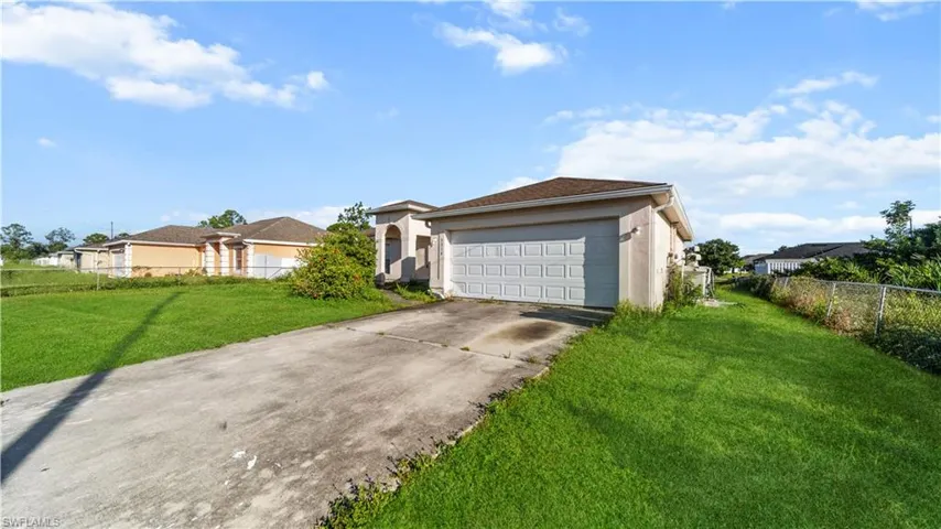 Ranch-style house with stucco siding, driveway, and a garage