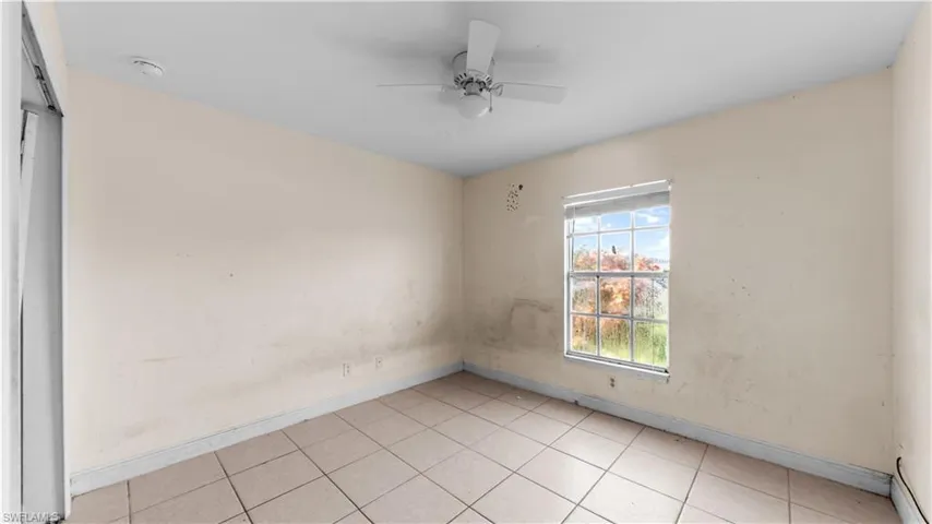 Unfurnished room with light tile patterned floors and a ceiling fan