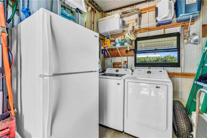 washer and dryer as well as extra refrigerator in storage room