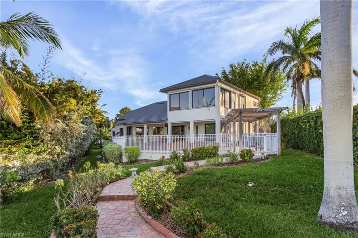 Rear view of house with a pergola and a yard