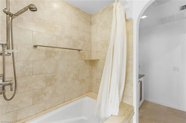 Bathroom with tile patterned floors and shower / tub combo