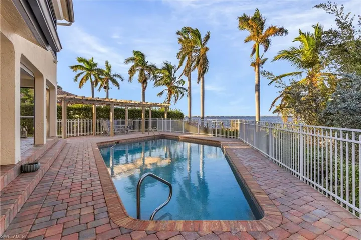 View of swimming pool with a water view, a pergola, and a patio