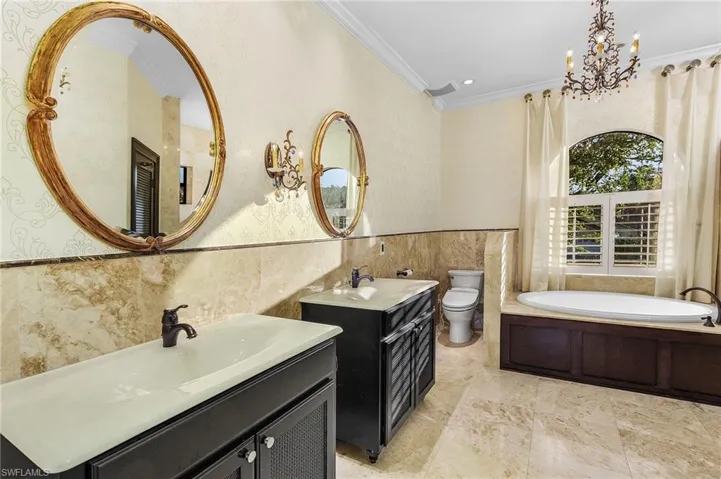 Bathroom featuring ornamental molding, vanity, tile walls, toilet, and a bathing tub