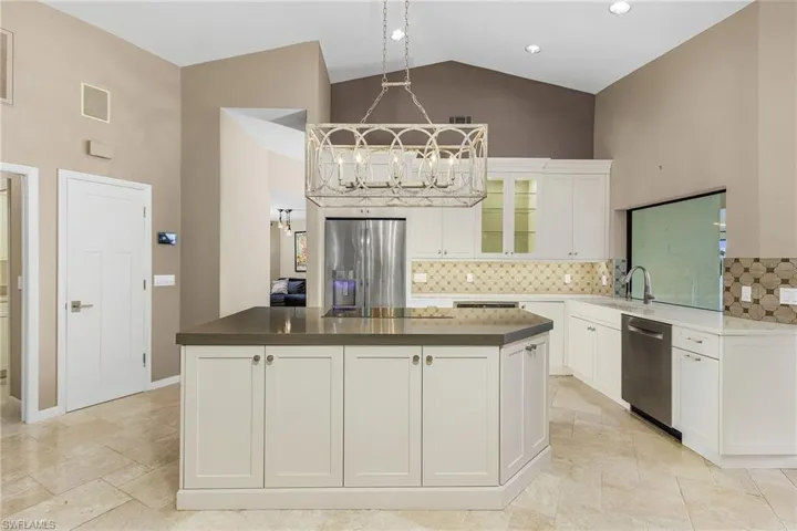 Kitchen with a center island, high vaulted ceiling, and appliances with stainless steel finishes