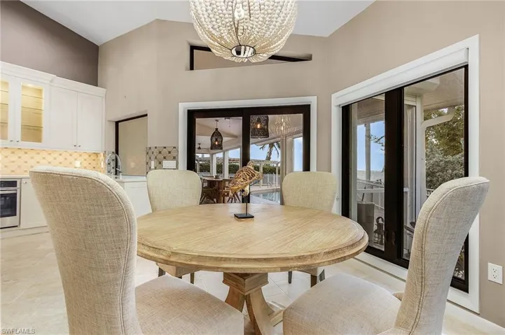 Dining room with light tile patterned flooring, a notable chandelier, and sink