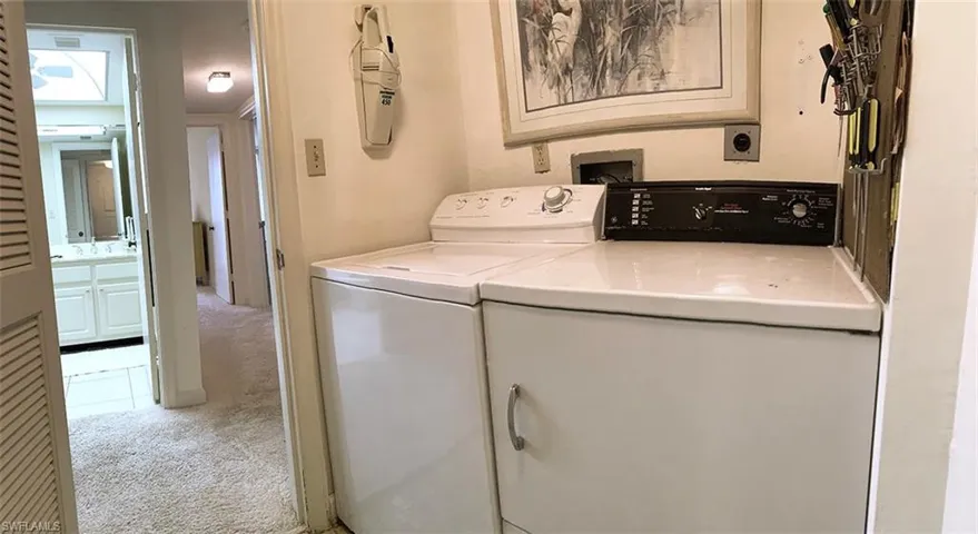 Laundry room featuring  washing machine and clothes dryer, AC System, Hot Water Heater, and Storage Shelves.
