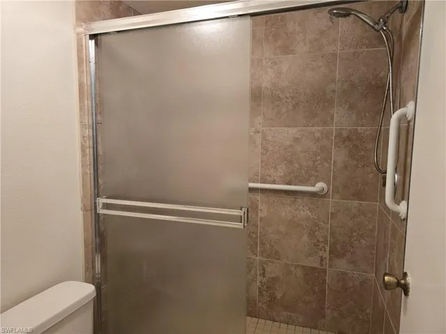 Bathroom featuring an enclosed shower and toilet