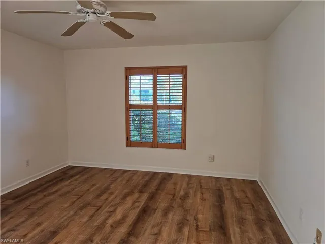 Master bedroom with ceiling fan and dark hardwood / wood-style floors