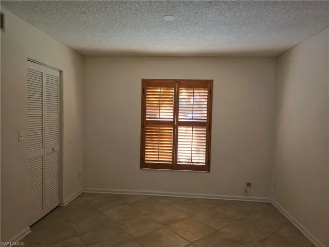 3rd bedroom with a closet and a textured ceiling