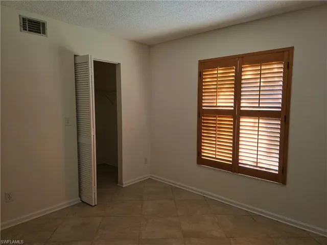 3rd bedroom with a spacious closet, a closet, and a textured ceiling