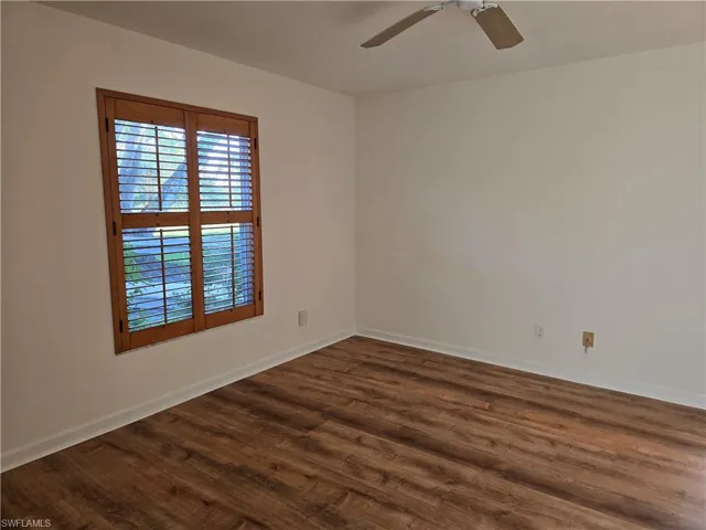 Master bedroom with dark wood-type flooring and ceiling fan
