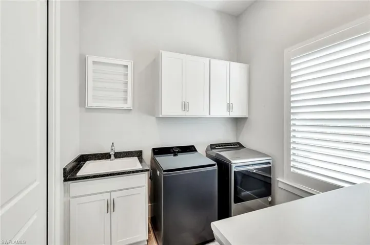 Laundry room with sink and cabinets