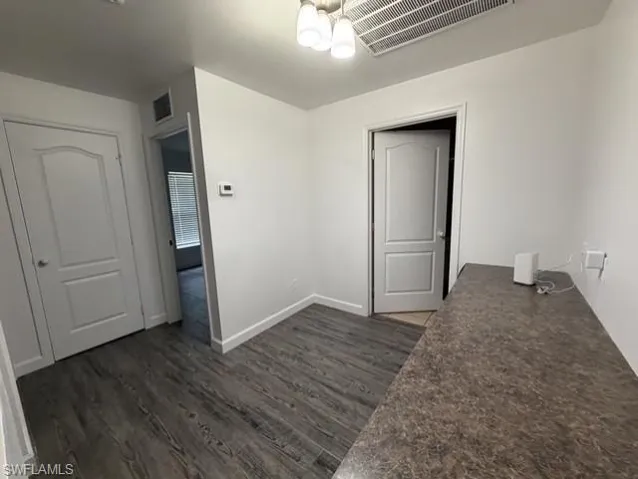 Interior space featuring wood-finish flooring, white painted walls, and a textured countertop
