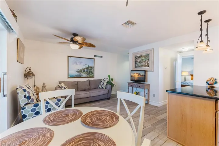 Open-concept living area featuring wood-finish flooring, a ceiling fan with light, and recessed lighting