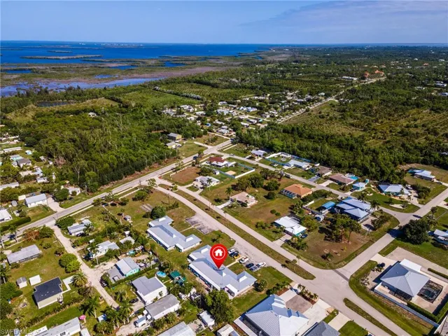 Aerial depiction of a residential area with proximity to a large body of water and natural preserves