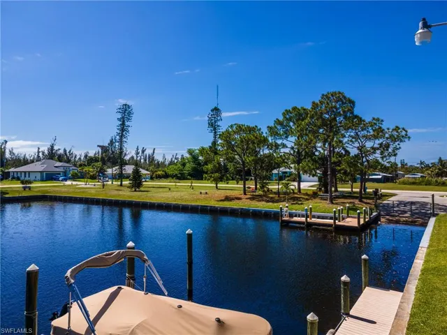 Waterfront property featuring a private boat dock, boat slip, and surrounding green space