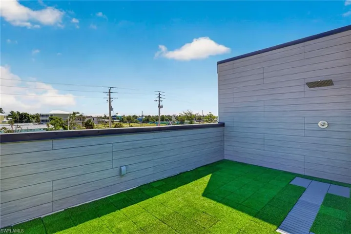 71 Mango Unit 2 Rooftop patio with faux turf flooring and a built-in outdoor shower
