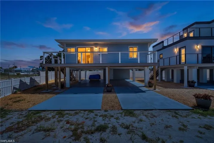2101 Cottage Elevated coastal construction featuring horizontal siding and a white picket fence