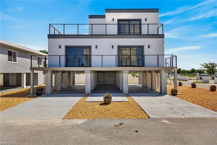 71 Mango - Modern new construction 2 Units 2 beds 2-1/2 baths residence featuring a white stucco exterior and black framed glass doors