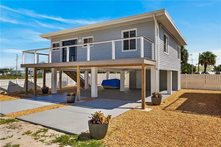 2101 Cottage Raised foundation home with siding exterior, elevated deck featuring cable railing, and a ground-level concrete pad
