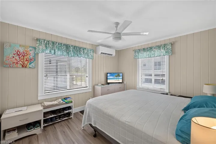2401 Cottage Ave Unit 2 -  bedroom featuring vertical paneling, two windows with horizontal blinds, and wood-finish flooring