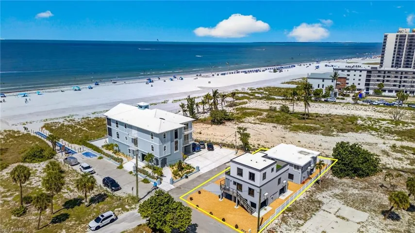 Gulfview properties Two modern multi-story structures with flat roofs, featuring exterior staircases and elevated outdoor decking