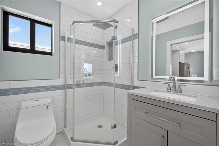 71 Mango Unit 2 bathroom featuring a glass-enclosed shower with subway tile surround and integrated niche