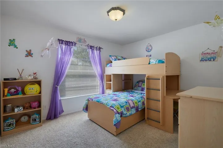 Bedroom featuring light carpet