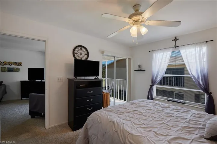 Bedroom featuring access to outside, light colored carpet, and a ceiling fan