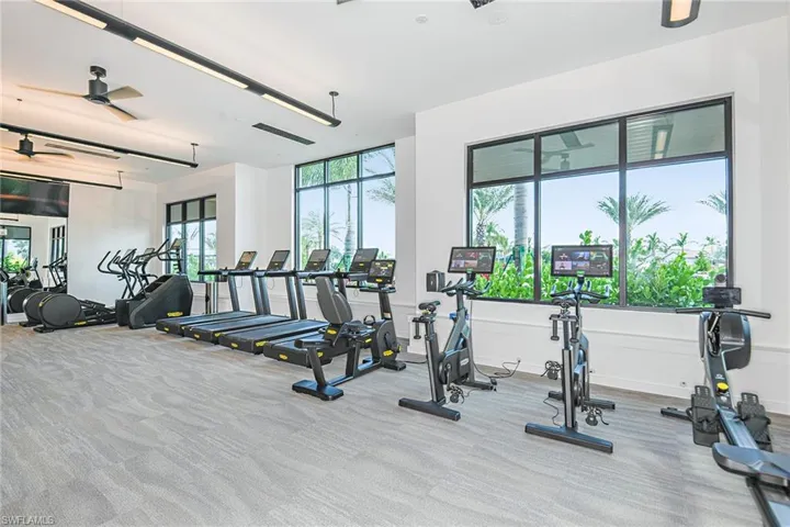 Gym featuring ceiling fan and light colored carpet