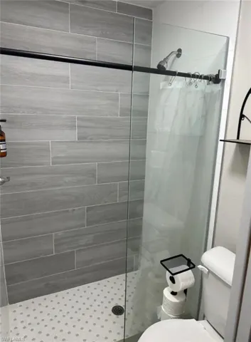 Bathroom featuring toilet and a shower with shower curtain