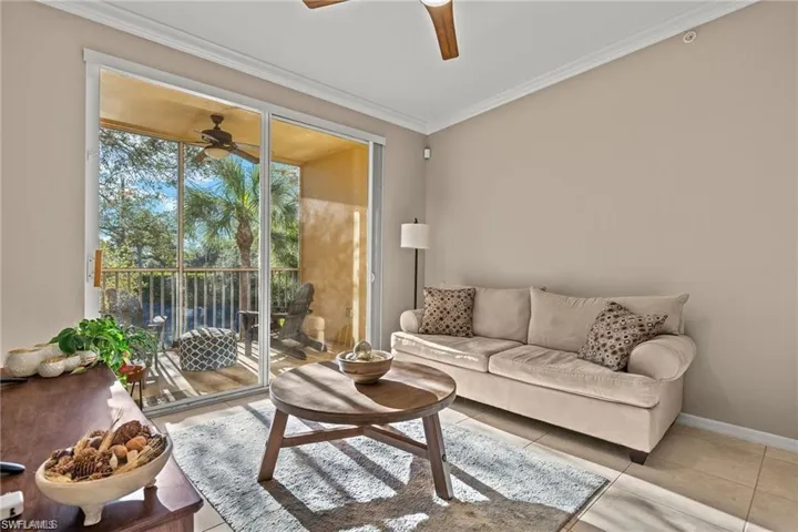 Tiled living room featuring ornamental molding and a ceiling fan