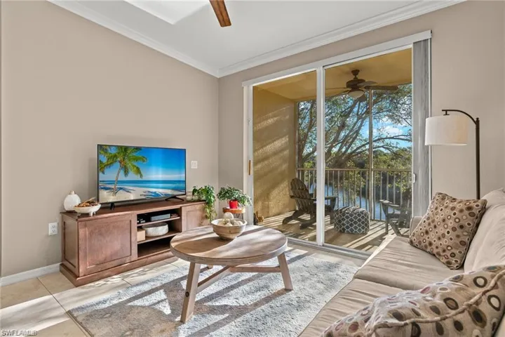 Living room with a ceiling fan and ornamental molding