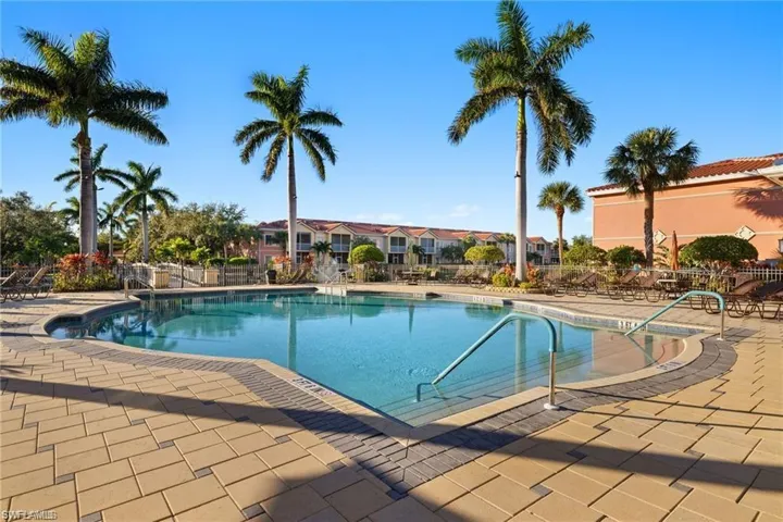 Community pool with a patio area and a residential view