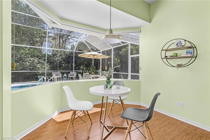 Dining space featuring a wealth of natural light, baseboards, a sunroom, and wood finished floors