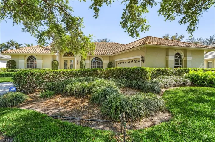 Mediterranean / spanish house with a garage, a tiled roof, and stucco siding