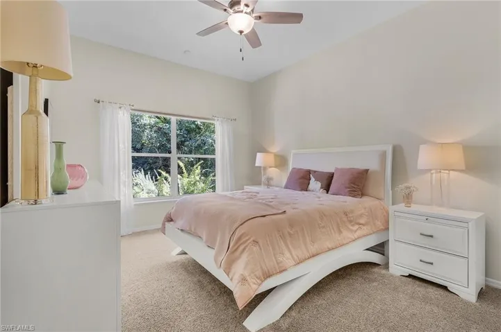Bedroom featuring baseboards, a ceiling fan, and light colored carpet