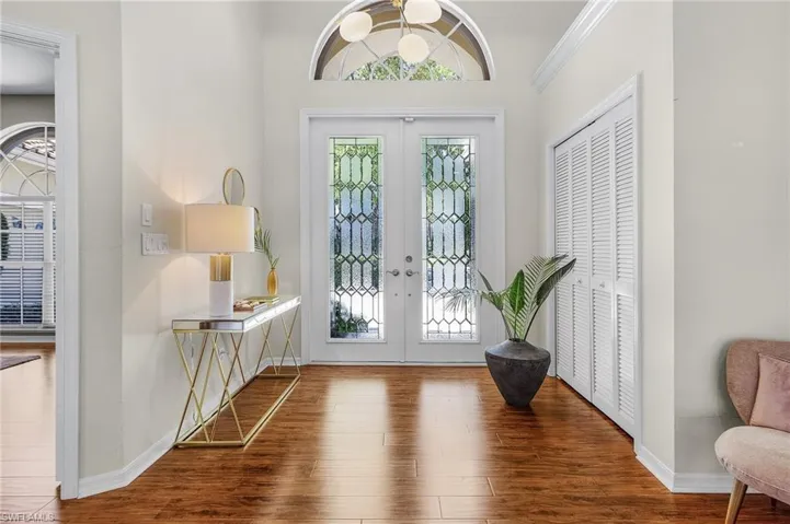 Entrance foyer featuring french doors, wood finished floors, and a healthy amount of sunlight