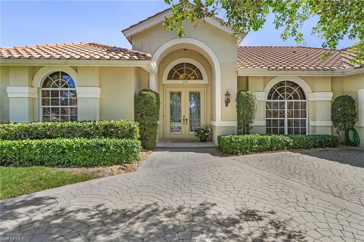Property entrance featuring french doors, a tile roof, and stucco siding