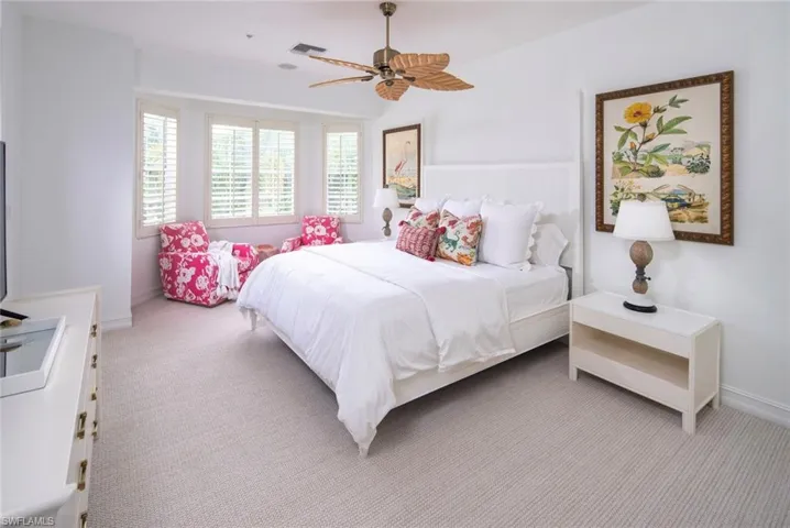 Bedroom with light colored carpet, a ceiling fan, and baseboards